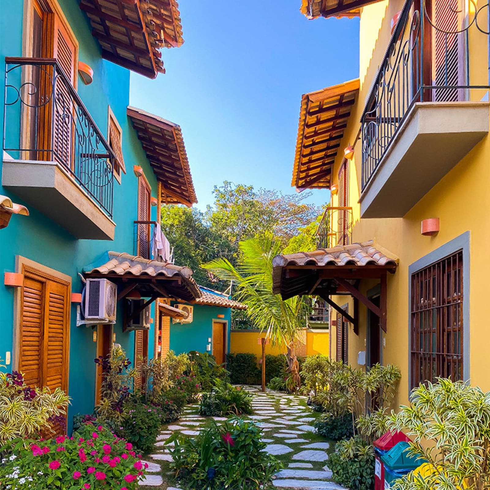 Pousada em Ilhabela — casas azul e amarelo entre plantas